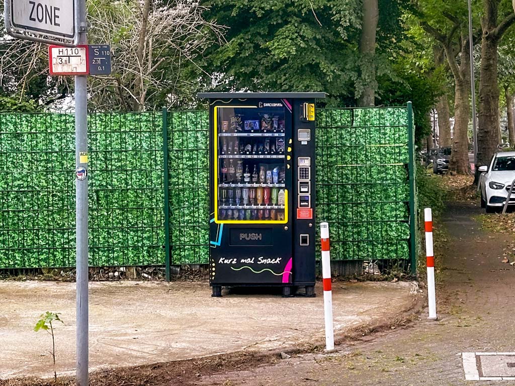 Snackomato vor einem grünen Zaun auf der Doerperhofstraße